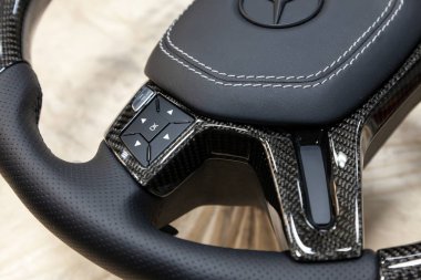 Novosibirsk, Rusya Federasyonu - 08.01.2018: atölye siyah bir araba direksiyon simidi sıkılır ve doğal deri ile delikli karbon yakın çekim Mercedes iz mat boya ile kaplı markası ile