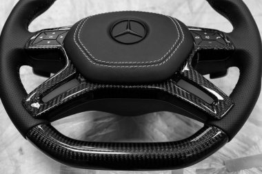 Novosibirsk, Rusya Federasyonu - 08.01.2018: atölye siyah bir araba direksiyon simidi sıkılır ve doğal deri ile delikli karbon yakın çekim Mercedes iz mat boya ile kaplı markası ile