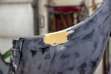 Demir hasarlı araç tampon detayını putty kullanarak atölyede tamir ve derz dolgu, kumlama ve boyama için hazırlanan.