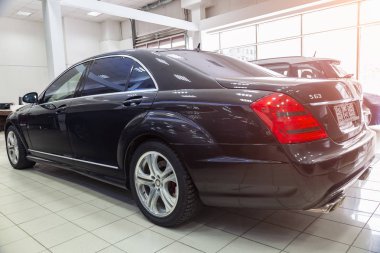 Novosibirsk, Rusya - 08.01.2018: Satılık Bayilik güneşli bir günde hazırlanan arka çeyrek görünüm bir Mercedes Benz iş S sınıfı tampon ve bir araba, bir uzun siyah limuzin, amg modeli açık havada, gövde
