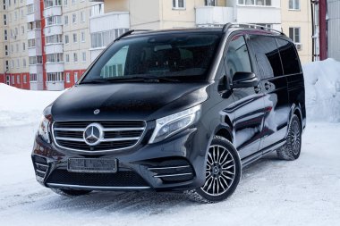 Novosibirsk, Rusya - 08.01.2018: Açık görünümünü yeni bir pahalı Mercedes Benz V-sınıf minivan tampon ve kaput bir araba, bir uzun siyah limuzin, model açık havada, hazırlanan satış için güneşli kış gününde 