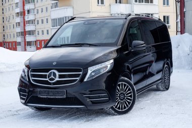 Novosibirsk, Rusya - 08.01.2018: Açık görünümünü yeni bir pahalı Mercedes Benz V-sınıf minivan tampon ve kaput bir araba, bir uzun siyah limuzin, model açık havada, hazırlanan satış için güneşli kış gününde 