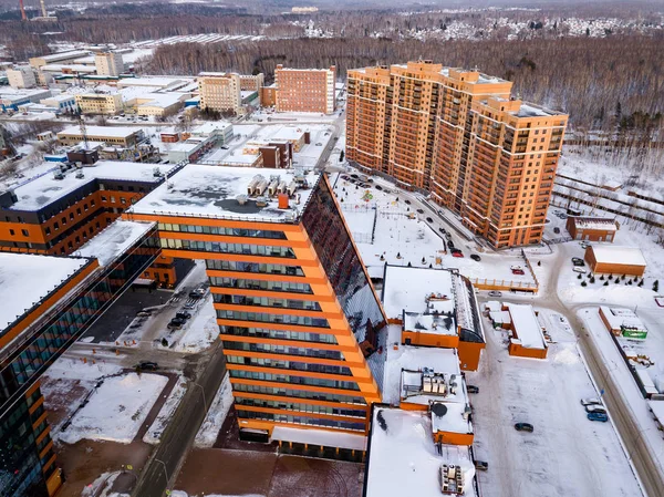 Aerial view of the community center and staff apartment building of academpark technopark of the Novosibirsk Academic Township - large building with laboratories and technical inventions in a winter