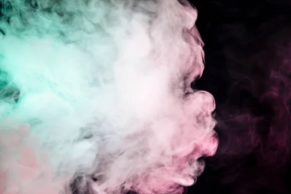 Multicolor, thick smoke, illuminated by colored in green and pink light against a dark black isolated background, welded with clubs and curls, rising from a steam of vape. Wind blow