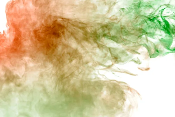 Multicolor, thick smoke, illuminated by colored in green and red light against a white isolated background, welded with clubs and curls, rising from a steam of vape. Wind blow