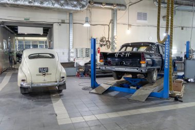 Novosibirsk, Rusya - 01.30.19: Arkadan görünüş iki Rus Klasik vintage arabalar gaz m20 pobeda ve iyi durumda bir asansör üzerinde duran bir tamir dükkanında 13 chaika