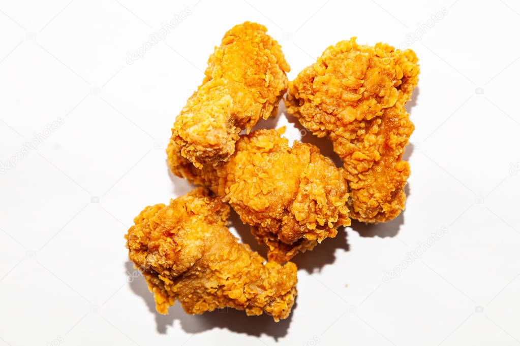 Close-up of fried delicious, appetizing four chicken wings made from fresh meat in a spicy sauce and breaded a popular dish in restaurants and fast food lie on a white isolated background