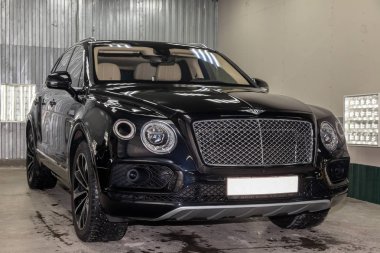 Novosibirsk, Rusya - 08.01.18: Ön görünümü lüks çok pahalı yeni siyah Bentley Bentayga araba tribünlerde Oto Servisi tamir bekliyor çamaşır kutusu