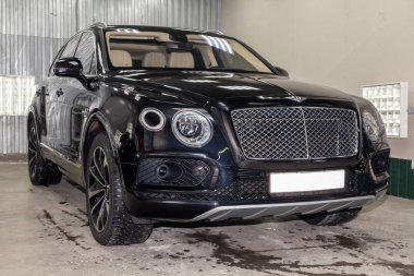 Novosibirsk, Rusya - 08.01.18: Ön görünümü lüks çok pahalı yeni siyah Bentley Bentayga araba tribünlerde Oto Servisi tamir bekliyor çamaşır kutusu