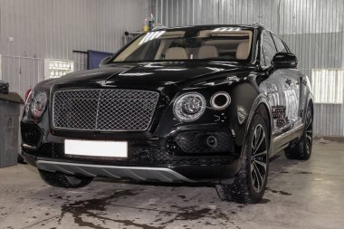 Novosibirsk, Rusya - 08.01.18: Ön görünümü lüks çok pahalı yeni siyah Bentley Bentayga araba tribünlerde Oto Servisi tamir bekliyor çamaşır kutusu