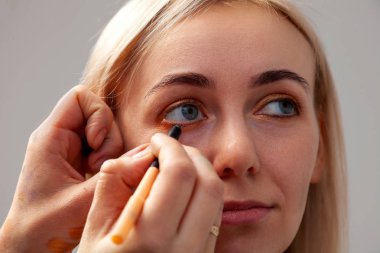 Makyöz bir elinde bir kalem yardımıyla çizer bir