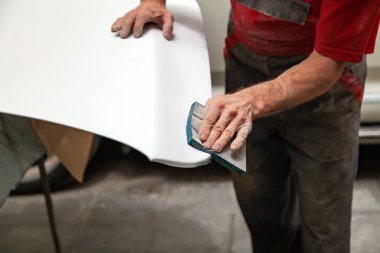 Bir araba öğesini tarafından s zımpara sünger kullanarak boyama için hazırlanması