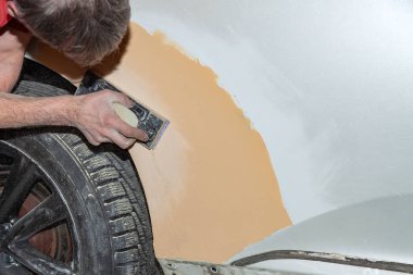 Bir araba öğesini zımpara gönderen tarafından s kullanarak boyama için hazırlanması