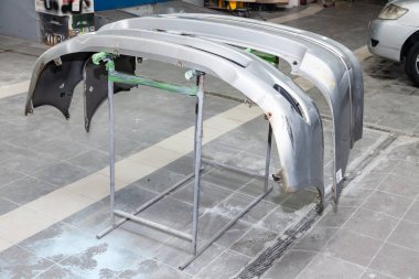 Üç otomobil tamponlar parçaları raflar üzerinde boya sonra yüklenir