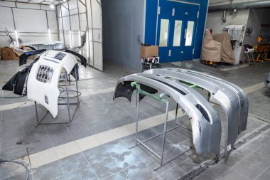 Üç otomobil tamponlar parçaları raflar üzerinde boya sonra yüklenir
