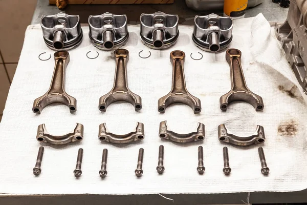 Engine connecting rods and pistons used and removed from a four-