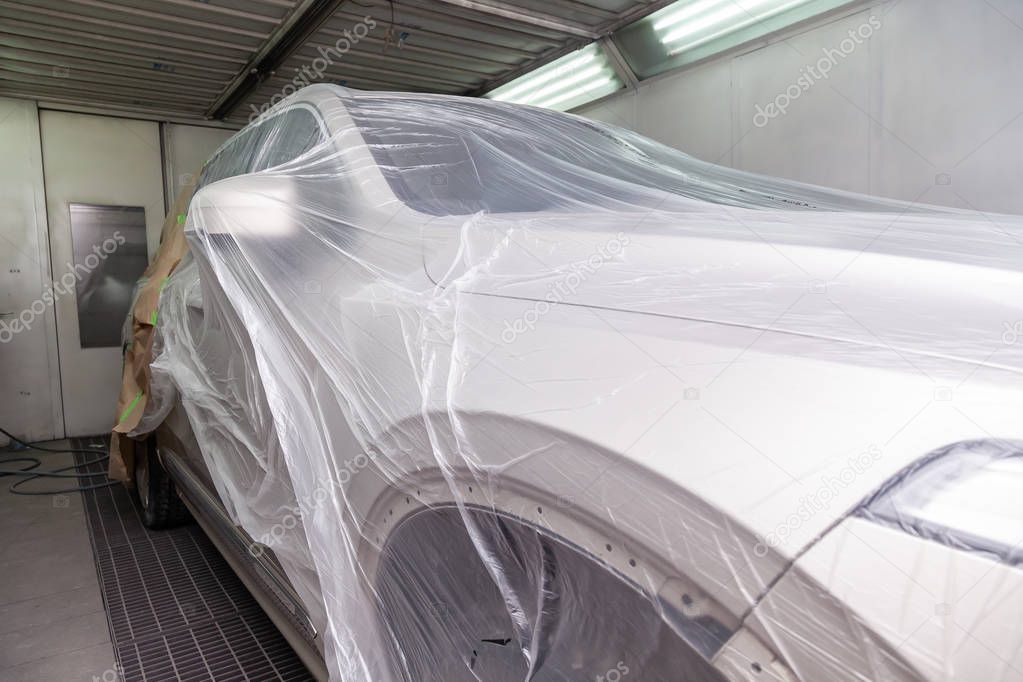 The car is a beige color covered with a transparent film to prot