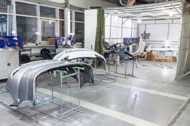 Üç otomobil tamponlar parçaları raflar üzerinde boya sonra yüklenir