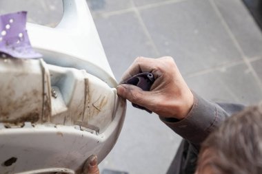 Bir adam boyama bir kazadan sonra bir araba body öğesi hazırlar