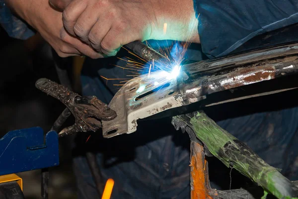 Close-up view strong man is a welder in blue working overalls wi — Stock Photo, Image