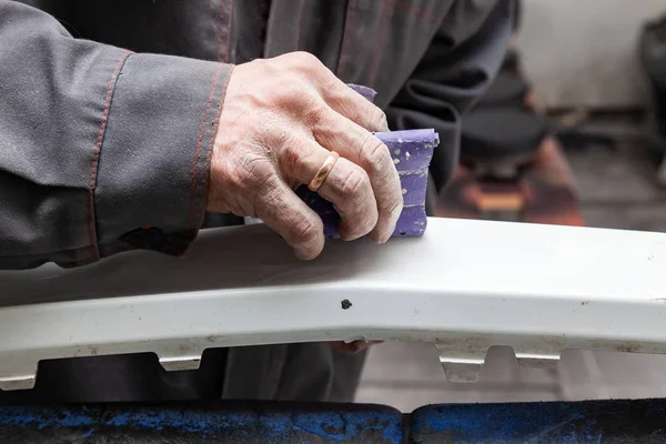 A man prepares a car body element for painting after an accident — Stock Photo, Image