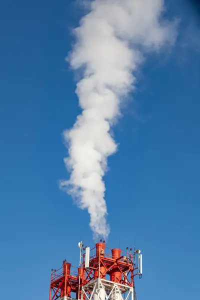 White harmful smoke coming out of the red-and-white pipes with m — Stock Photo, Image