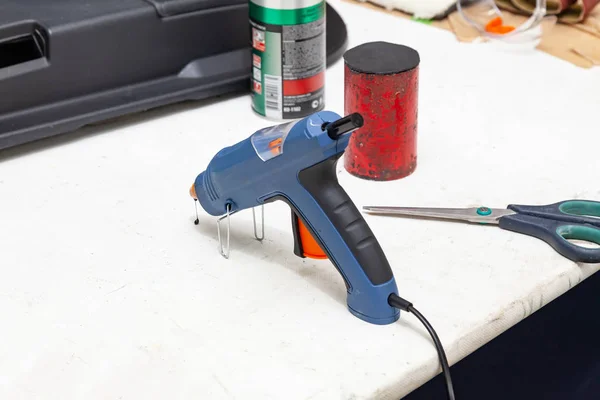 Electric glue gun for squeezing blue glue on the workbench for n