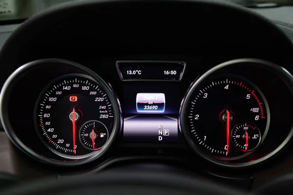 The dashboard of the car is glowing blue with red arrows at nigh