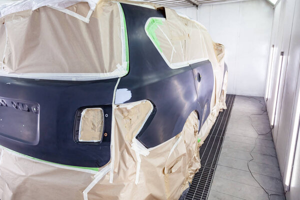 Большой черный автомобиль полностью покрыт бумагой и клеем та
