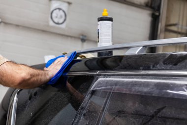 Kaputunu ovuşturan bir erkek işçinin ellerine yakın çekim görünümü