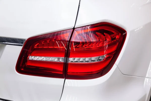 Крупный план на заднем светодиодном тормозе красного цвета на белом автомобиле — стоковое фото