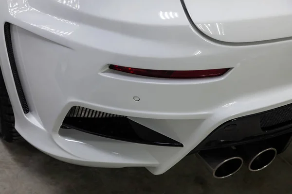 The rear bumper of a tuned car is white with a double exhaust no — Stock Photo, Image