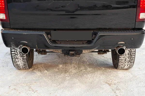 Close-up of a black luxury car bumper of an SUV with two side tu