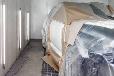 Büyük beyaz bir araba tamamen kağıt ve yapışkan ta kaplıdır