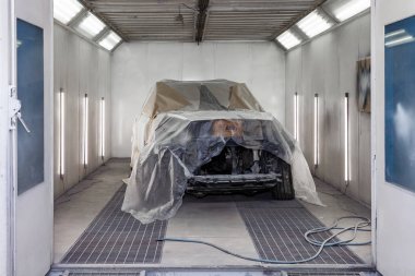 Büyük beyaz bir araba tamamen kağıt ve yapışkan ta kaplıdır