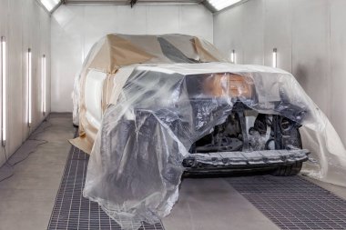 Büyük beyaz bir araba tamamen kağıt ve yapışkan ta kaplıdır