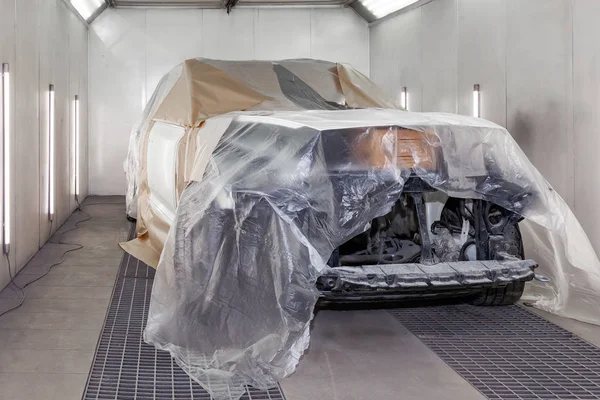 Büyük beyaz bir araba tamamen kağıt ve yapışkan ta kaplıdır