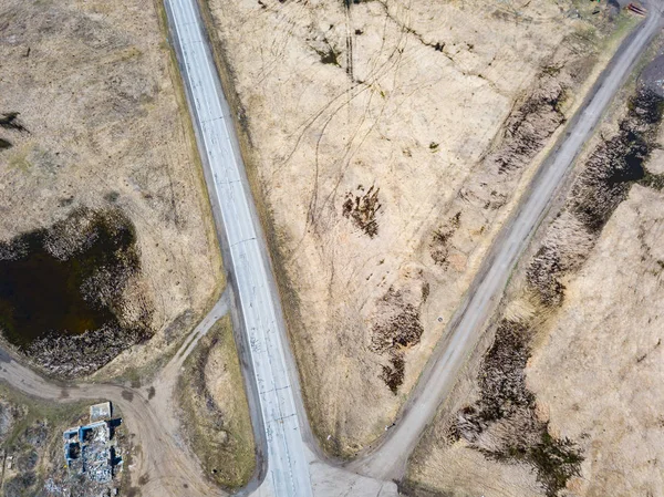 Aerial view of the intersection of asphalt and ground roads in t