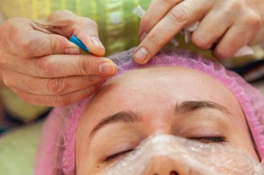 Genç bir kız ile kozmetik işlemler sırasında bir kanepede yatıyor