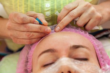 Genç bir kız ile kozmetik işlemler sırasında bir kanepede yatıyor