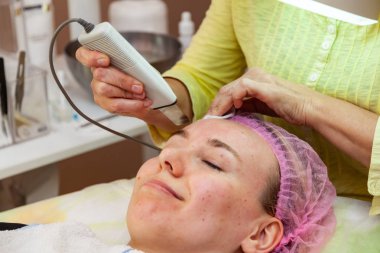 Genç bir kız kanepede saçında pembe bir şapkayla yatarken.