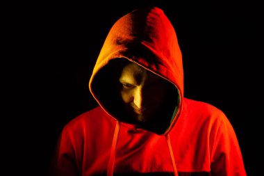 Yetişkin bir adam bir ps gibi bir sırıtış ile kaputun altından dışarı bakar