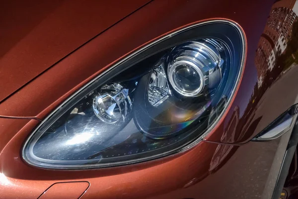 Front xenon headlight view of Porsche Cayenne 958 2013 in brown 