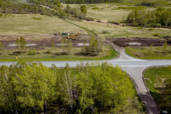 Veduta aerea di un paesaggio con un'autostrada in un campo tra verde — Foto Stock