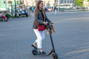 Beyaz pantolon genç bir kız bir c siyah elektrozamik sürmek