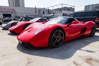 Üç araba Marussia Motors model B1 kırmızı renk ve siyah çatı 