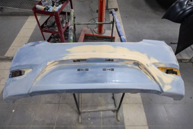 T ile bir kaza sonrası mavi bir arabanın arka tampon onarımı