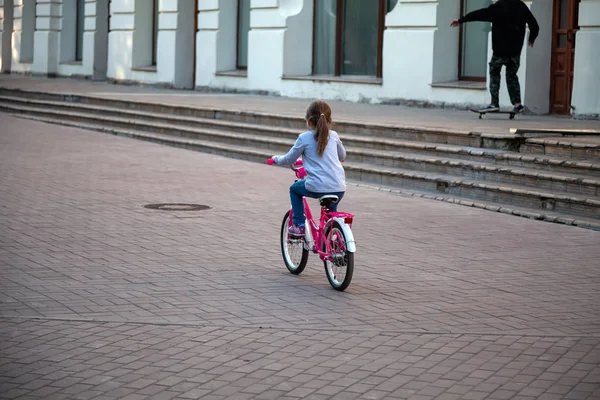 Pihenés a parkban a nyáron, ahol lány lovagolni rózsaszín kerékpár — Stock Fotó