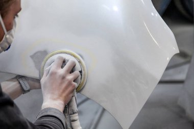 Bir araba öğesini sander ve macun tarafından kullanarak boyama için hazırlanması