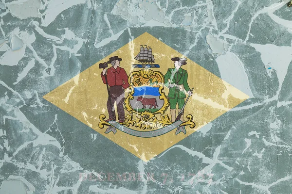 La bandera nacional del estado estadounidense Delaware en contra de un wal gris —  Fotos de Stock